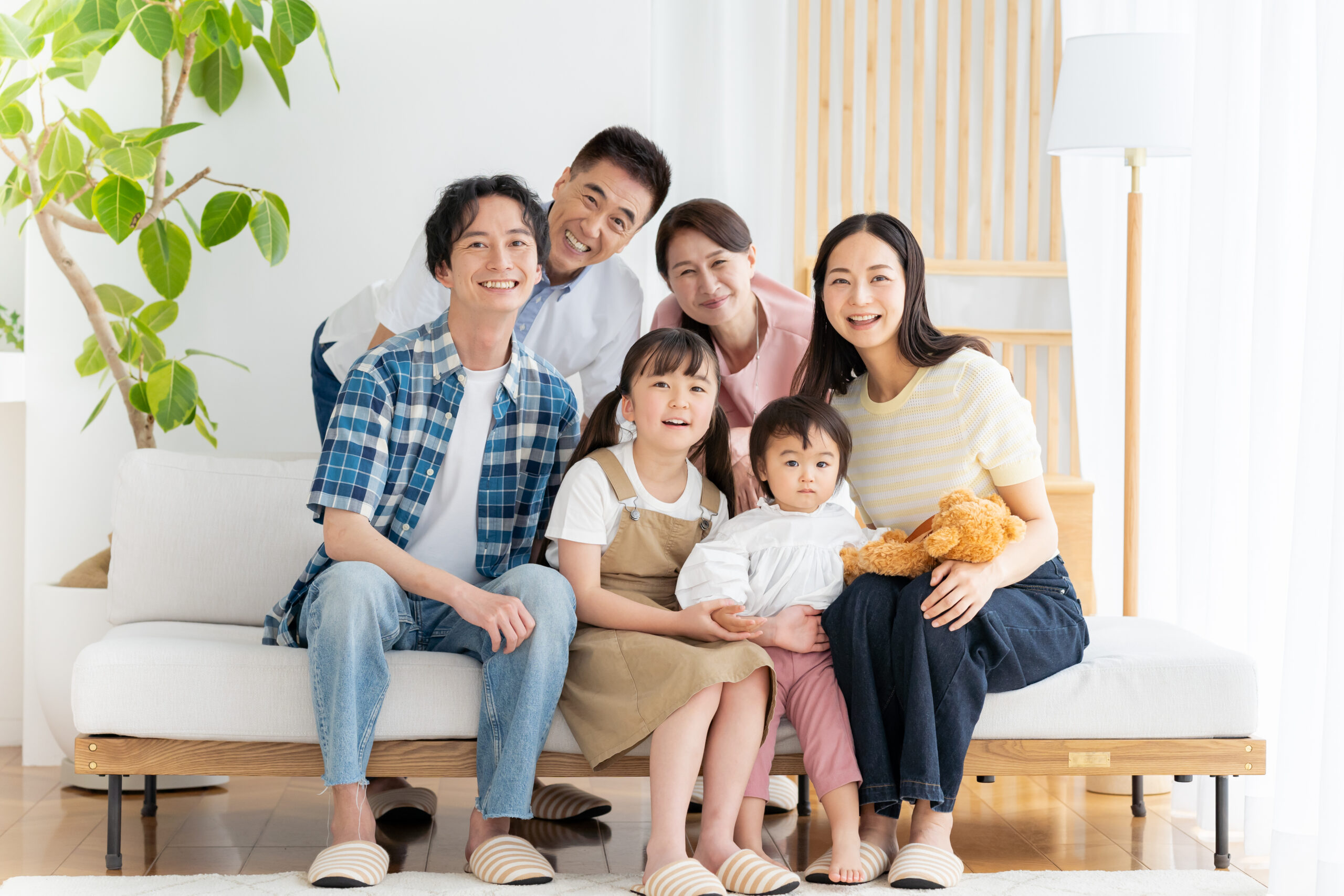 祖父母・両親・子どもたちがリビングで笑い合う三世代家族の団らん