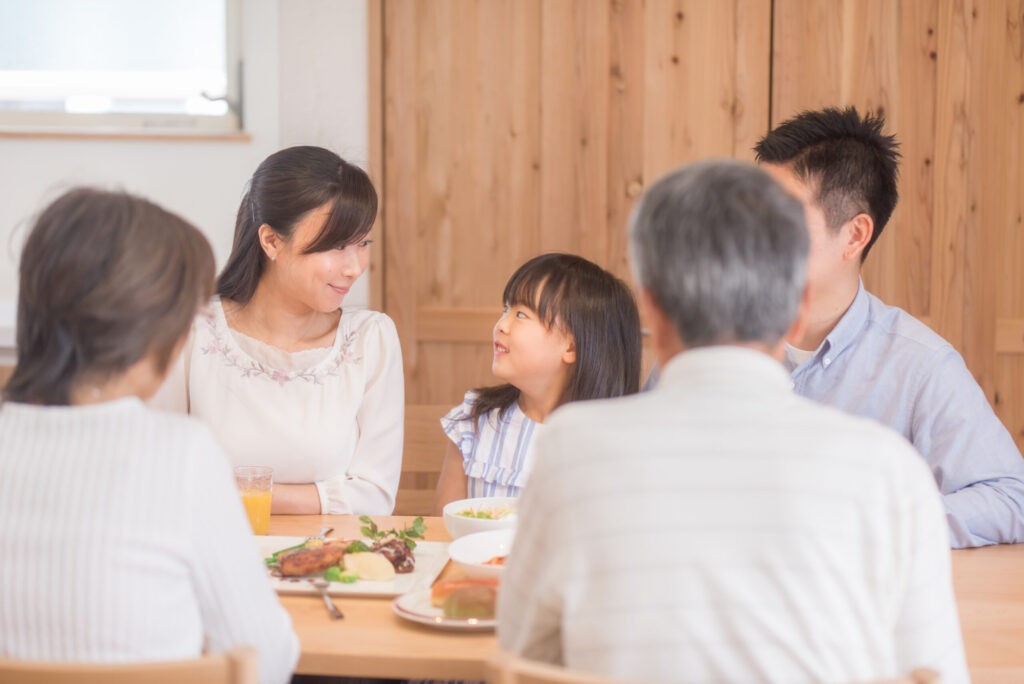 食卓を囲んで家族のかたちと予算を話し合う三世代家族