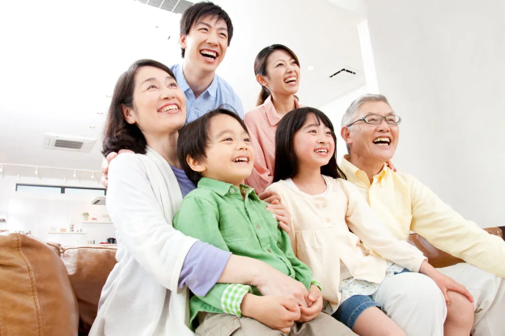 ソファで頬を寄せ合う三世代家族