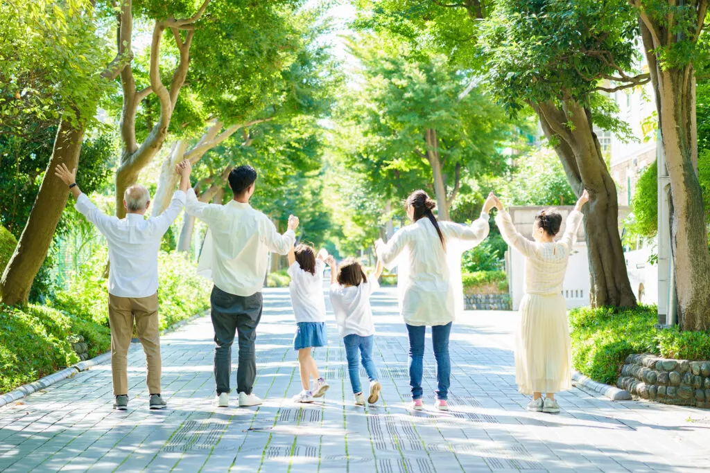 祖父母・両親・子どもたちが手をつなぎ歩く、三世代家族の散歩道